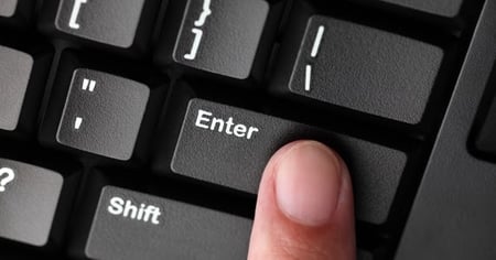 Person pressing the enter key on their keyboard