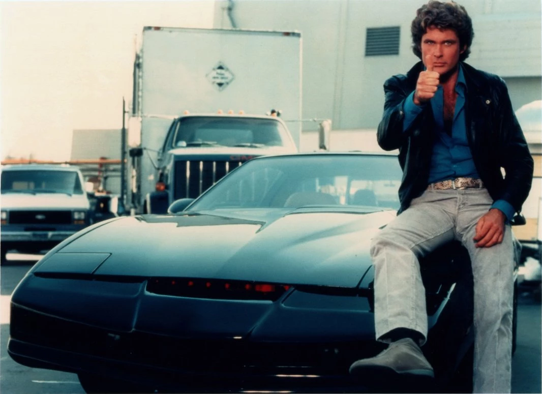 Michael Knight sitting on Kitt and giving thumbs up